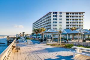 a large building next to a beach with benches at Daytona Beach in Daytona Beach