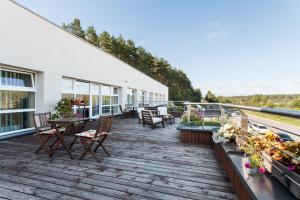 a deck with tables and chairs on a building at Mineraliniai Apartamentai in Druskininkai