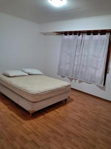 a bedroom with a bed and a window at El descanso in Mar del Plata