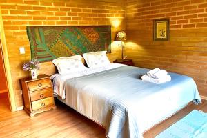 una camera da letto con due letti e un muro di mattoni di Casa Baú’au Vista Única Conforto em Familia a São Bento do Sapucaí Altre 90 foto
