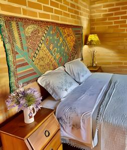una camera da letto con un letto e un tavolo con dei fiori sopra di Casa Baú’au Vista Única Conforto em Familia a São Bento do Sapucaí