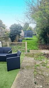 een tuin met twee banken in het gras bij Cosy appartement 45m2 vu et accès jardin commun in Outreau