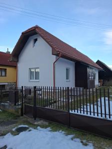 een wit huis met een hek ervoor bij Chata pod vŕškami Važca in Važec