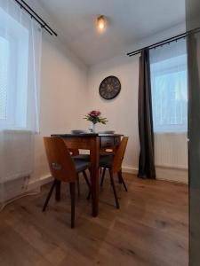 een eettafel met 2 stoelen en een klok aan de muur bij Chata pod vŕškami Važca in Važec