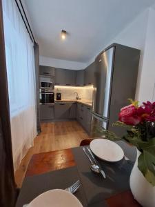 een keuken met een tafel en een roestvrijstalen koelkast bij Chata pod vŕškami Važca in Važec +17 foto's