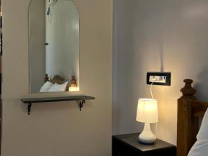 een slaapkamer met een spiegel, een lamp en een bed bij BV Residency in Pondicherry