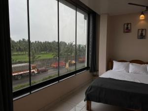 a bedroom with a large window with a view of a truck at BV Residency in Pondicherry