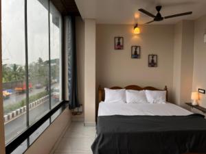 a bedroom with a bed and a large window at BV Residency in Pondicherry
