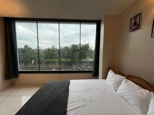 een slaapkamer met een bed en een groot raam bij BV Residency in Pondicherry +67 foto's