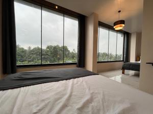 een slaapkamer met een groot bed en grote ramen bij BV Residency in Pondicherry