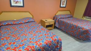 En eller flere senge i et værelse på Relax Motel by Hotel O Arlington TX