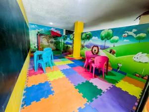 ein Kinderzimmer mit bunten Stühlen und einem Wandbild in der Unterkunft Caruaru Pallace Hotel in Caruaru