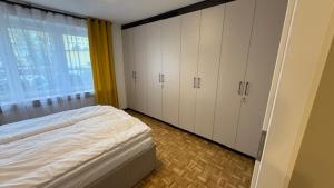 a bedroom with white cabinets and a bed with a window at W Centrum in Piła