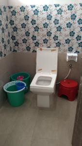 een badkamer met een wit toilet in een kamer bij Rainbow Guest House in Mahabalipuram