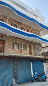 een scooter geparkeerd voor een gebouw met blauwe deuren bij Rainbow Guest House in Mahabalipuram