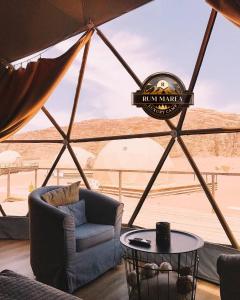 een yurt met een stoel en een tafel met uitzicht op het strand bij RUM MAREA lUXURY CAMP in Wadi Rum