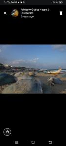 Een screenshot van een foto van een strand met een boot. bij Rainbow Guest House in Mahabalipuram +27 foto's
