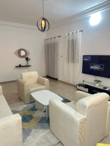 ein Wohnzimmer mit weißen Möbeln und einem Flachbild-TV in der Unterkunft Deckon 