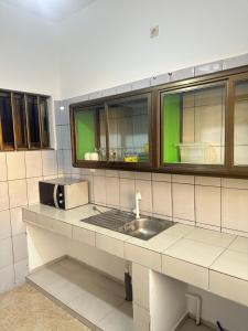 eine Küche mit Spüle und zwei Fenstern in der Unterkunft Deckon  + 13 Fotos