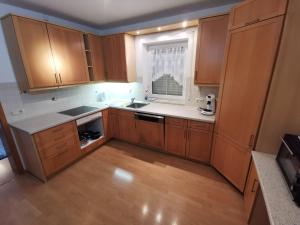 een lege keuken met houten kasten en een raam bij Lounge house in Burgau +8 foto's