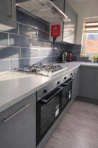 a kitchen with a stove top oven in a kitchen at The Stadium Rooms Elegant and Comfy Stay in London