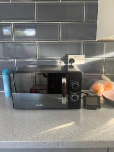 a black toaster oven sitting on a kitchen counter at The Stadium Rooms Elegant and Comfy Stay in London