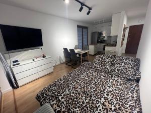 a bedroom with a bed and a flat screen tv at Zakrzówek Apartament z Jacuzzi in Krakow
