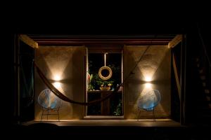 two chairs sitting in front of a window at night at Ecohotel Luzul in Nuquí