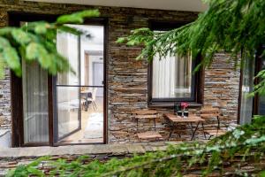 un edificio in mattoni con patio arredato con tavolo e sedie di Mountain Bliss 1-BR a Borovets