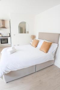 una camera da letto bianca con un grande letto con lenzuola bianche di Flat 1 - Eign St Hereford a Hereford