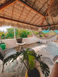 ein Zimmer mit einer Hängematte, einem Stuhl und einer Pflanze in der Unterkunft Pousada Casinha Branca in Cruz