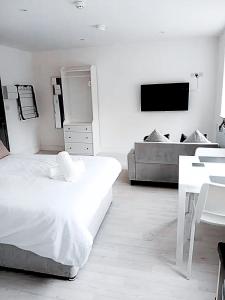 una stanza bianca con un letto, un tavolo e una TV di Flat 1 - Eign St Hereford a Hereford
