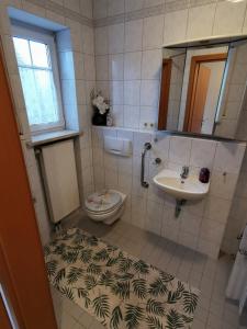 een badkamer met een wastafel, een toilet en een spiegel bij Lounge house in Burgau