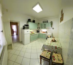 a kitchen with mint green cabinets and a table with a table sidx sidx sidx at Panna Ház in Jászapáti