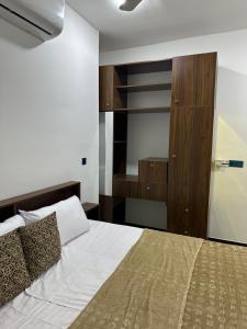 a bedroom with a large bed and a closet at Jadriya Serviced Residences in Baghdad