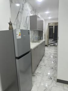 a kitchen with white appliances and marble walls at Jadriya Serviced Residences in Baghdad
