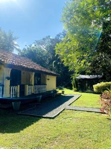 a small house with a balcony on a yard at Villa Meleno in Weligama