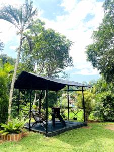 a picnic shelter in a park with a palm tree at Villa Meleno in Weligama