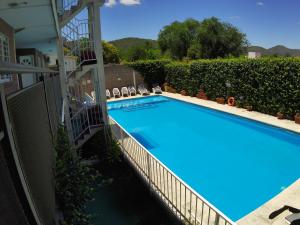 a swimming pool with chairs next to a building at Altos del Plata in Villa Carlos Paz