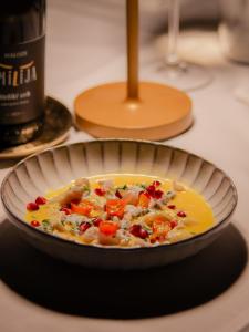Un tazón de sopa en una mesa con una botella de vino. en Ljubljana Resort Hotel & Camping, en Liubliana 97 fotos más