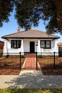 een wit huis met een hek ervoor bij Perth Boutique Heritage in Perth
