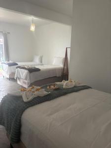 two beds in a room with towels on top of them at VILA DO RIO in Santo Amaro