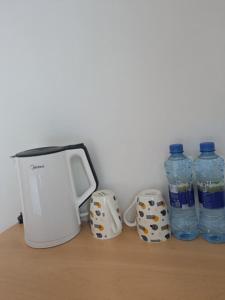 een broodrooster en twee flessen water op een tafel bij Huasheng Hotel in Dar es Salaam