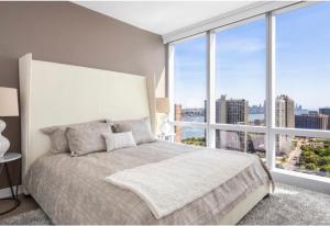 ein Schlafzimmer mit einem großen Bett mit einem großen Fenster in der Unterkunft Everlasting Reality in Fort Lee
