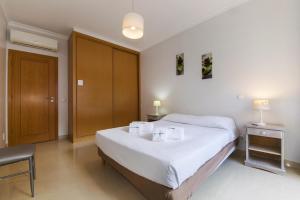 een slaapkamer met een bed en een houten deur bij C05 - Convento Apartment in Lagos