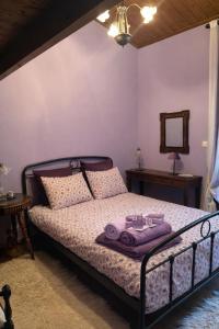 een slaapkamer met een bed met paarse lakens en een spiegel bij Horizon Nest Parnassos Villa Chalet! in Eptalofos