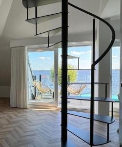 a living room with a spiral staircase and a large window at Lake House 10 - 4 Person Lake view apartment! in Offingawier