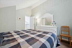 a bedroom with a bed and a mirror and a chair at Whispering Dunes At Singing Sands All Season in Tobermory