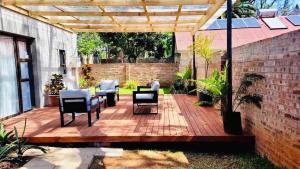 een houten terras met stoelen en een tafel erop bij Place on Oak 4 in Bulawayo