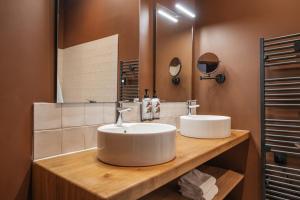 un baño con dos lavabos y un espejo en Maison Soyeuse, en Briançon